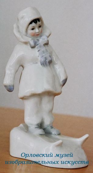   Л.М. Бугай (1935-2012). Автор формы.  Е.Н. Лупанова (1910-1973). Автор росписи.  Статуэтка «Маленькая лыжница». 1962. Фарфор, надглазурная полихромная роспись. Высота - 17,8 см.  Выполнена на Ленинградском фарфоровом заводе им. М.В. Ломоносова.  Орловский музей изобразительных искусств.